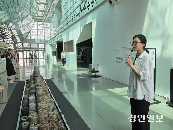 이지연 작가가 작품 ‘잿소리’에 대해 설명하고 있다. 잿소리는 버려진 연탄 200장을 활용해 만든 작품으로, 경기도미술관 전시 ‘기다림이 끝나는 날에도’에서 만날 수 있다. 2025.7.24 /이시은기자 see@kyeongin.com