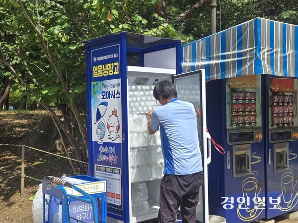 지난 30일 오후 2시께 한 직원이 하남시청 앞 공원에 설치된 얼음 냉장고에 생수를 보충하고 있다. 2025.7.30 /김태강기자 think@kyeongin.com