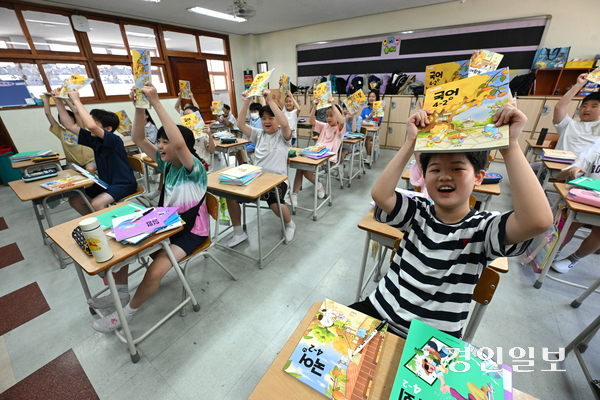 5일 오전 수원시 영통구 잠원초등학교에서 여름방학을 마치고 개학한 4학년 학생들이 교과서를 들어 보이며 환하게 웃고 있다. 2025.8.5 /최은성기자 ces7198@kyeongin.com