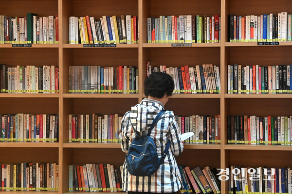 수원시내 한 도서관을 찾은 시민이 책을 고르고 있다. 사진은 기사 내용과 관련 없음. /경인일보DB