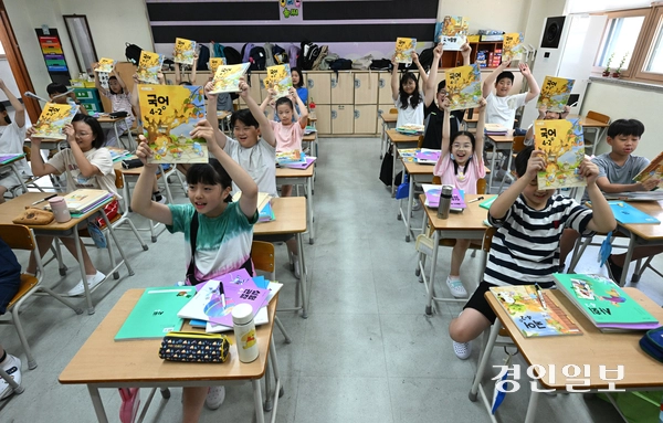 5일 오전 수원시 영통구 잠원초등학교에서 여름방학을 마치고 개학한 4학년 학생들이 교과서를 들어 보이며 환하게 웃고 있다. 2025.8.5 /최은성기자 ces7198@kyeongin.com