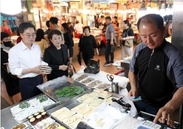 김동연 경기도지사가 배우자 정우영 여사와 함께 지난 9일 수원 못골시장을 찾아 장을 보며 상인에게 민생회복 소비쿠폰의 효과를 묻고 있다./김동연 도지사 인스타그램 캡처