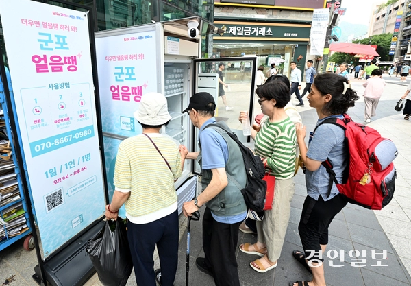무더운 날씨가 이어진 18일 오후 군포시 산본로데오거리에 설치된 무인 냉장고 ‘군포 얼음땡’에서 시민들이 물을 가져가고 있다. 2025.8.18 /최은성기자 ces7198@kyeongin.com