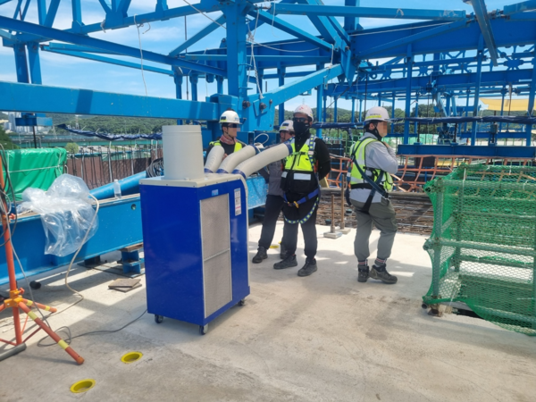 한 건설현장 근로자들이 이동형 에어컨으로 더위를 식히고 있다. /한국수자원공사 제공