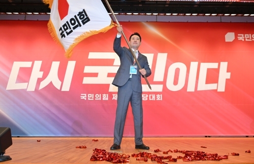국민의힘 장동혁 신임 당 대표가 26일 서울 여의도 국회도서관에서 열린 제6차 전당대회 결선에서 당 대표로 선출된 뒤 당기를 흔들고 있다. 2025.8.26 /연합뉴스