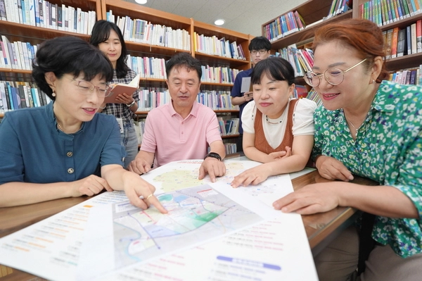 수원시 서둔동 주민들이 우리동네 자치계획을 들여다보며 회의를 하고 있다. /수원시 제공