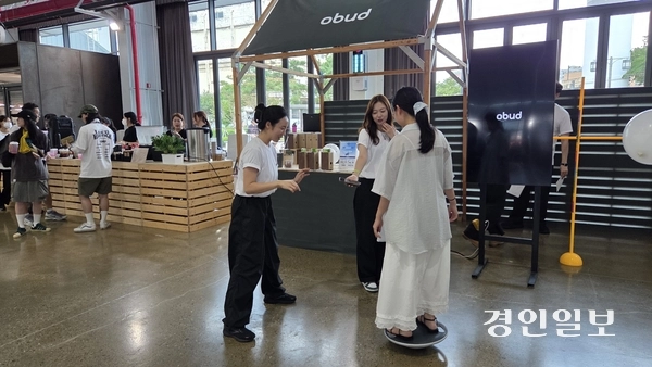 지난 6일 인천 상상플랫폼에서 열린 ‘2025 인천 웰메디 페스타 위크’ 메인행사에서 한 시민이 웰니스·피트니스 예약 플랫폼인 ‘오붓(Obud)’이 운영하는 특별 이벤트에 참여해 건강 관련 정보를 듣고 있다. 2025.9.6 /김희연기자 khy@kyeongin.com