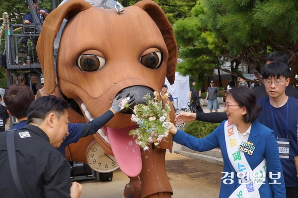 과천시의회 이주연 의원이 지난 13일 중앙공원에서 2025 과천공연예술축제 pre-이벤트로 진행된 로그 퍼포먼스 행사에서 로그의 코에 꽃다발을 갖다대며 즐거워하고 있다. 2025.9.13 과천/박상일기자 metro@kyeongin.com
