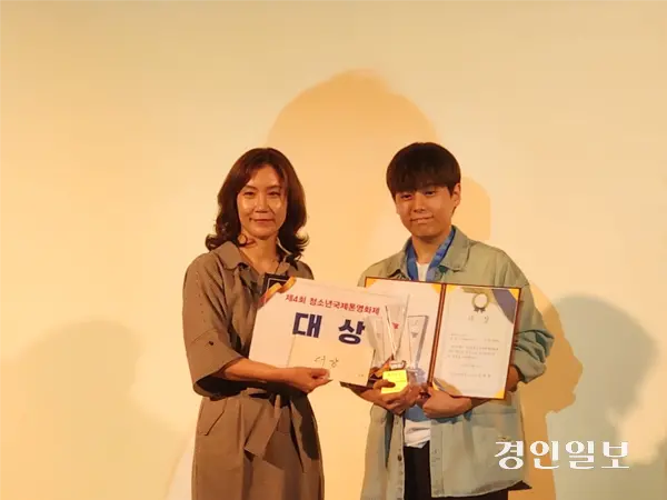 지난 13일 경기아트센터 컨벤션홀에서 열린 제4회 청소년국제폰영화제 시상식에서 ‘나와너’라는 작품으로 최우수상을 수상한 정제환(오른쪽) 학생이 트로피를 들고 기념촬영을 하고 있다. 2025.9.13 /김형욱기자 uk@kyeongin.com
