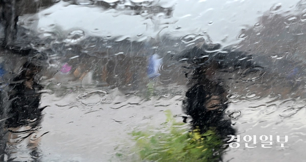 기습적인 폭우가 쏟아진 17일 오전 수원시 화성 행궁에서 우산을 쓴 시민들이 발걸음을 옮기고 있다. 2025.9.17 /임열수기자 pplys@kyeongin.com