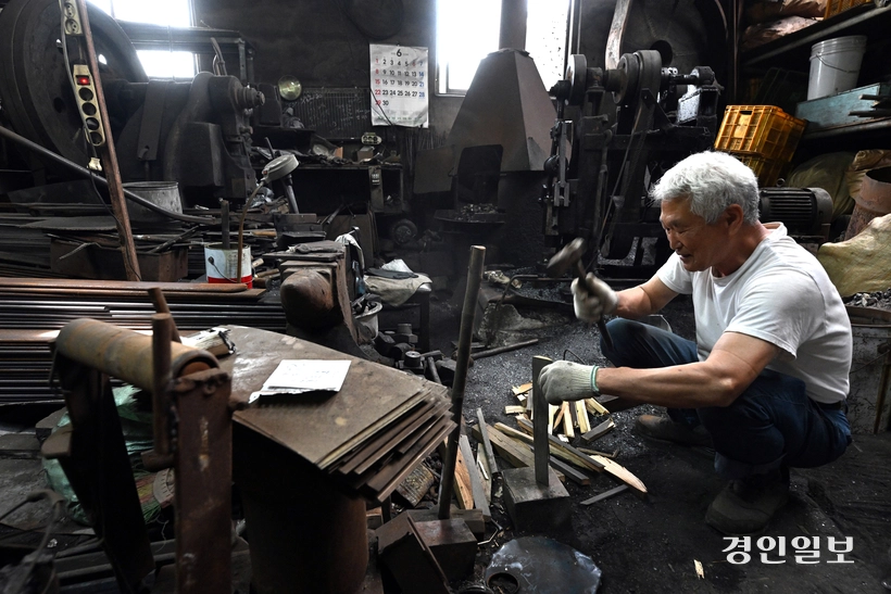 불을 지피기 위해 망치로 장작을 패고 있다.