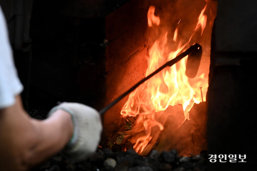 쇠를 달구기 위해 화덕에 불을 피우고 있다.