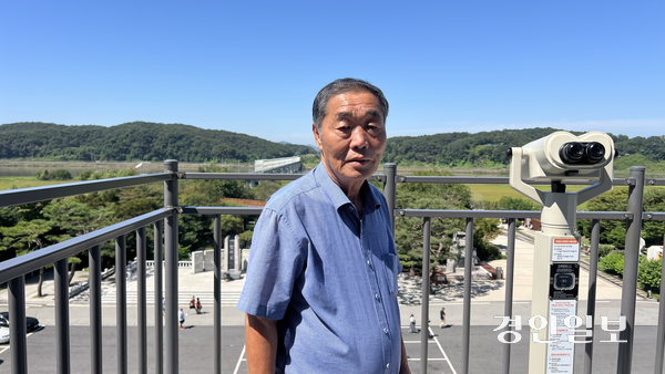 이완배 파주 통일촌 이장이 임진각 3층 전망대에서 민통선 내에 있는 마을을 배경으로 사진 촬영을 하고 있다.