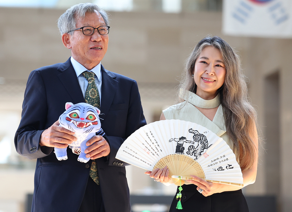 유홍준 국립중앙박물관장(왼쪽)과 넷플릭스 애니메이션 ‘케이팝 데몬 헌터스’의 매기 강 감독이 21일 서울 용산구 국립중앙박물관에서 선물을 주고 받은 뒤 기념촬영을 하고 있다. 2025.8.21 /연합뉴스