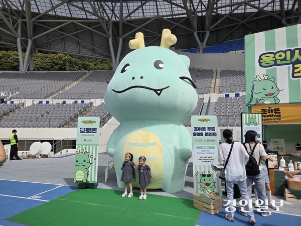 지난 27일 용인미르스타디움에서 열린 조아용 페스티벌에서 대형 ‘조아용’과 사진을 찍고 있는 어린이들.  2025.9.27 용인/오수진기자 nuri@kyeongin.com