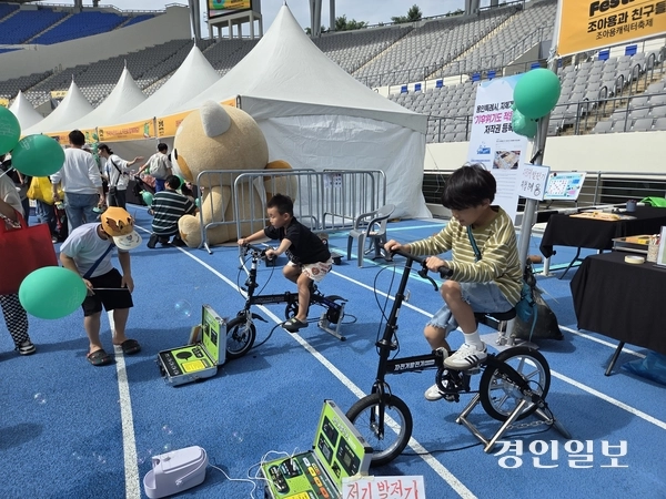 지난 27일 용인 미르스타움에서 열린 조아용 페스티벌 체험 부스에서 어린이들이 자전거 발전기 체험을 하고 있다. 2025.9.27 용인/오수진기자 nuri@kyeongin.com