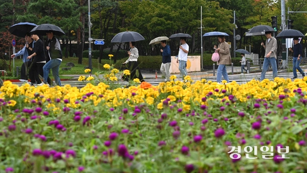 가을비가 내린 13일 수원시 영통구청사거리 횡단보도에서 우산을 쓴 시민들이 발걸음을 옮기고 있다. 2025.10.13 /최은성기자 ces7198@kyeongin.com