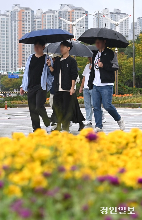 가을비가 내린 13일 수원시 영통구청사거리 횡단보도에서 우산을 쓴 시민들이 발걸음을 옮기고 있다. 2025.10.13 /최은성기자 ces7198@kyeongin.com