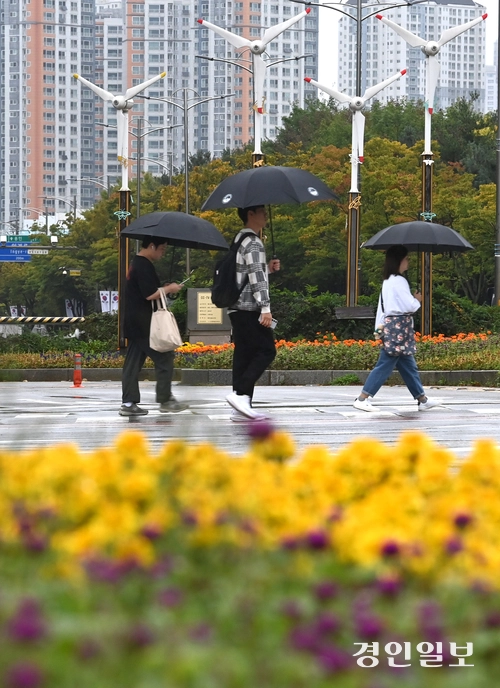 가을비가 내린 13일 수원시 영통구청사거리 횡단보도에서 우산을 쓴 시민들이 발걸음을 옮기고 있다. 2025.10.13 /최은성기자 ces7198@kyeongin.com