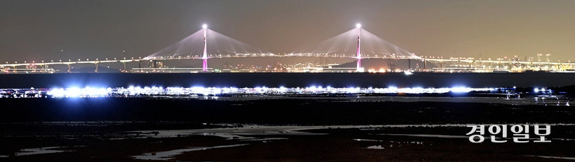 해루질을 하기 위해 영흥도 갯벌을 찾은 방문객들의 불빛이 인천대교를 배경으로 불야성을 이루고 있다. /조재현기자 jhc@kyeongin.com