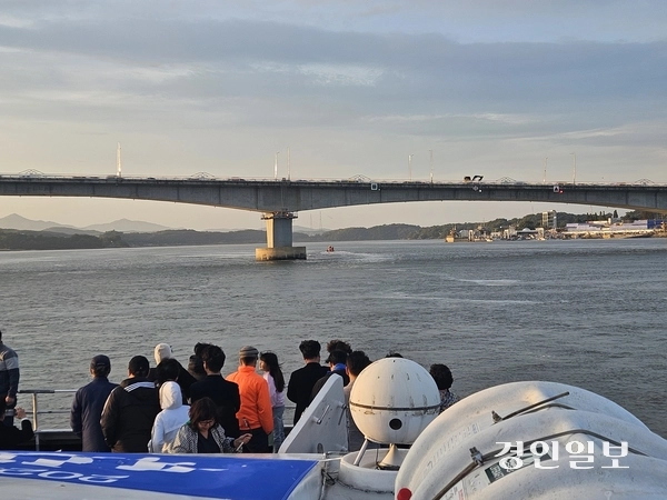 25일 첫 여객 항해길에 오른 아라호가 염하를 거쳐 초지대교 앞에 도착하자, 시민들이 갑판에 나와 이를 바라보고 있다. 2025.10.25 김포/김연태기자 kyt@kyeongin.com