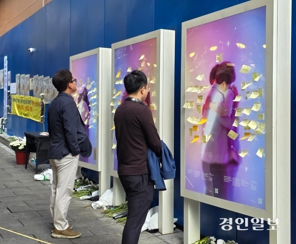 29일 이태원역 1번 출구 옆 참사 현장. 시민들이 추모 관련 게시판에 붙은 포스트잇을 지켜보고 있다. 2025.10.29 /고건기자 gogosing@kyeongin.com