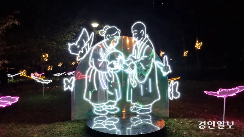 구리 빛 축제의 첫번째 조형물은 장자못 설화 속 탁발승에게 쌀을 주는 며느리 조형물이다. 시아버지의 잘못을 사과하고 시주하는 며느리 주변에 나비가 팔락인다. 2025.10.27 구리/권순정기자 sj@kyeongin.com