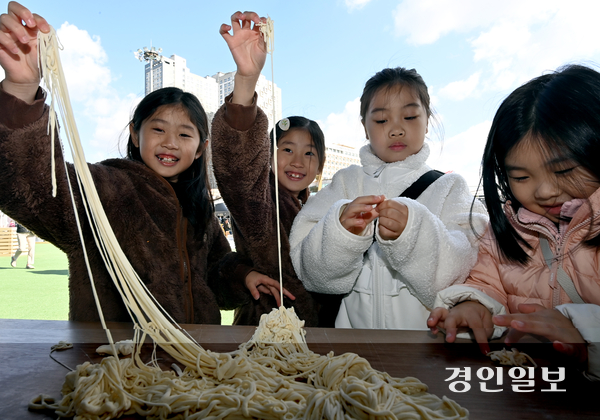 2일 인천시 중구 상상플랫폼에서 열린 ‘1883 인천 짜장면 축제’의 수타체험관을 찾은 어린이들이 손으로 만든 면을 신기한 듯 늘려보고 있다. 2025.11.2 /김용국기자 yong@kyeongin.com