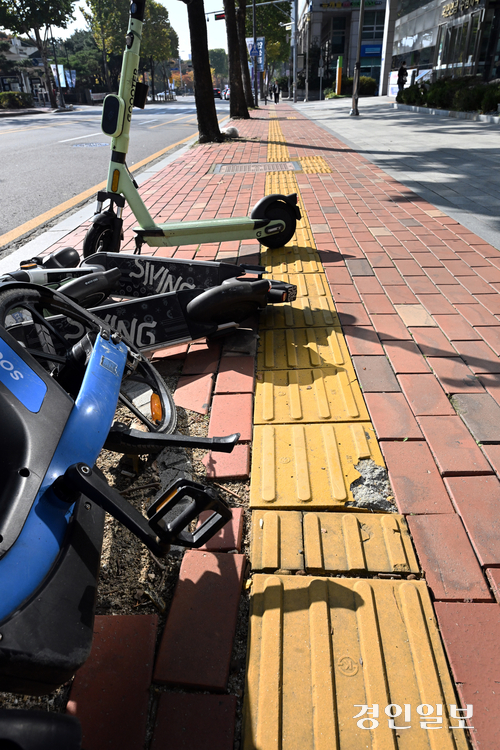 점자의 날인 4일 오전 수원시내 한 도로변 인도 점자블록이 개인형 이동장치(PM)에 막혀있고, 파손된 채 방치돼 시각장애인 안전이 우려되고 있다. 2025.11.4 /임열수기자 pplys@kyeongin.com