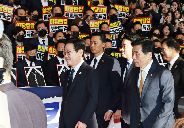 이재명 대통령이 4일 내년도 정부 예산안에 대한 시정연설을 하기 위해 서울 여의도 국회에 도착해 피켓시위를 하는 국민의힘 의원들 앞을 지나고 있다. 국민의힘 의원들은 추경호 전 원내대표에 대한 내란특검팀의 영장청구에 반발하며 야당 탄압 중단을 촉구했다. 2025.11.4 /국회사진기자단