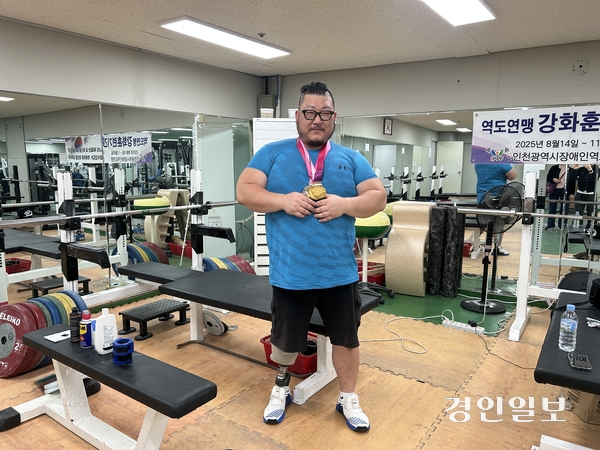 7일 오전 인천시 장애인역도팀 훈련장에서 만난 전나라수 선수가 제45회 전국장애인체전에서 딴 메달을 목에 걸고 포즈를 취하고 있다. 2025.11.7/백효은기자100@kyeongin.com