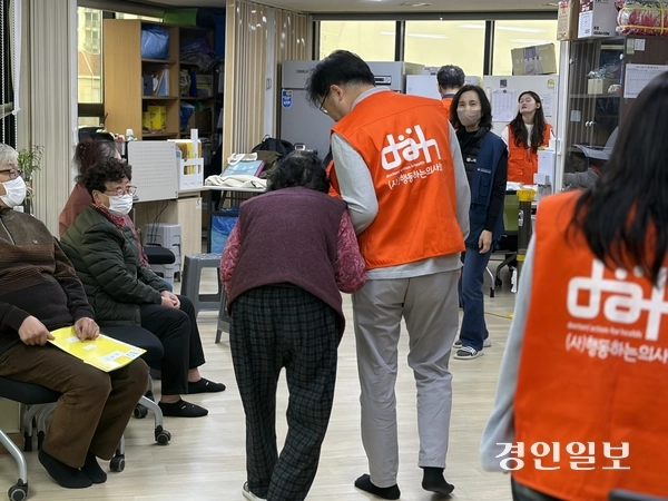 행동하는의사회 인천지부 소속 남희태(51) 의사가 지난 8일 인천시 동구 만석동 희망키움터에 마련된 무료 진료소에서 주민을 부축하고 있다. 2025.11.8 /조경욱기자 imjay@kyeongin.com