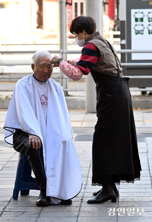 10일 오후 수원역 광장에서 한 봉사자가 노숙자에게 이발봉사를 해주고 있다. 2025.11.10 /임열수기자 pplys@kyeongin.com