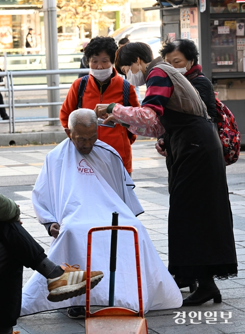 10일 오후 수원역 광장에서 한 봉사자가 노숙자에게 이발봉사를 해주고 있다. 2025.11.10 /임열수기자 pplys@kyeongin.com
