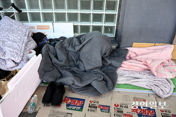 경기도내 외국인 노숙인들이 증가하고 있지만 이에 대한 공식적인 가이드라인조차 없어 겨울철 외국인 노숙인 관리에 어려움을 겪고 있다. 10일 오후 수원역 광장에서 한 외국인 노숙인이 이불을 덮고 누워 휴식을 취하고 있다. 2025.11.10 /임열수기자 pplys@kyeongin.com
