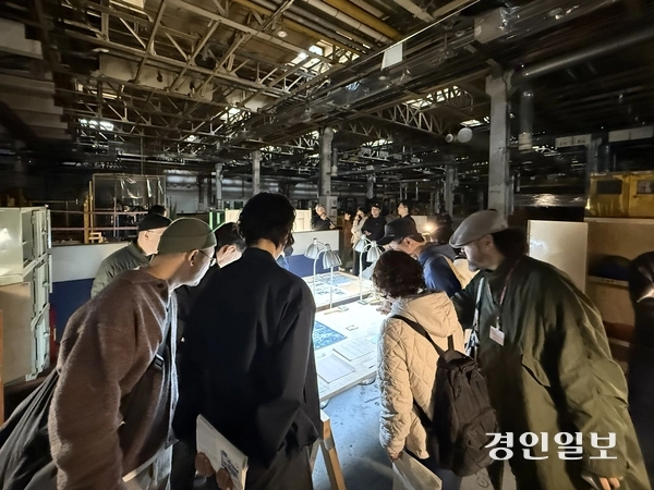 한국지엠 부평2공장 차체공장 내 전시된 공장의 건축 역사 관련 아카이브를 관람객들이 살피고 있다. 2025.11.7 /박경호기자 pkhh@kyeongin.com