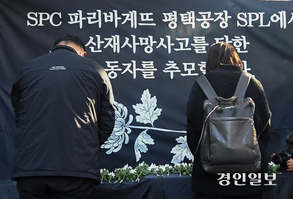 2022년 10월 20일 서울 양재동 SPC그룹 본사 앞에서 열린 SPL 평택공장 소스 배합기 끼임 사고로 사망한 여성 청년노동자 추모 행사에서 헌화 후 묵념하는 시민들. /경인일보DB