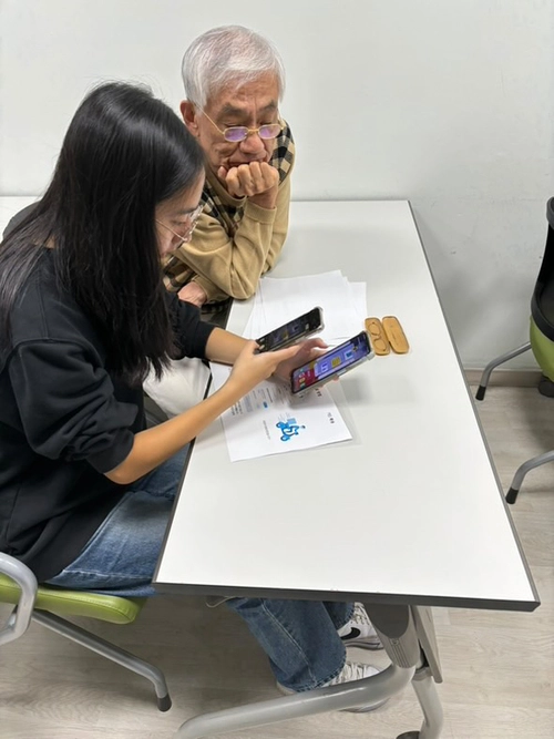 ‘이지바이츠(EZBytes) 클럽’ 학생이 어르신들에게 스마트폰 이용 방법을 알려주고 있다. /채드윅 국제학교 제공