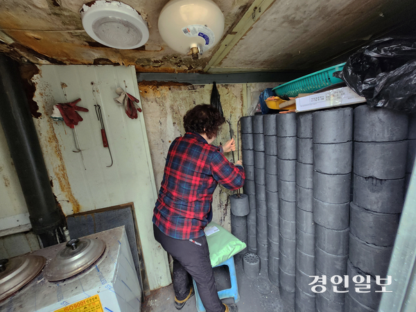 27일 비닐하우스 거주지인 과천 꿀벌마을에서 주민 배모씨가 연탄을 갈고 있다. 2025.11.27 /김형욱기자 uk@kyeongin.com