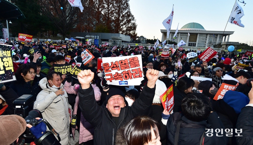 탄핵소추안이 가결된 지난해 12월 14일 오후 서울 여의도 국회의사당 앞에서 뉴스를 지켜보던 한 시민이 환호하고 있다. 2024.12.14 /조재현기자 jhc@kyeongin.com