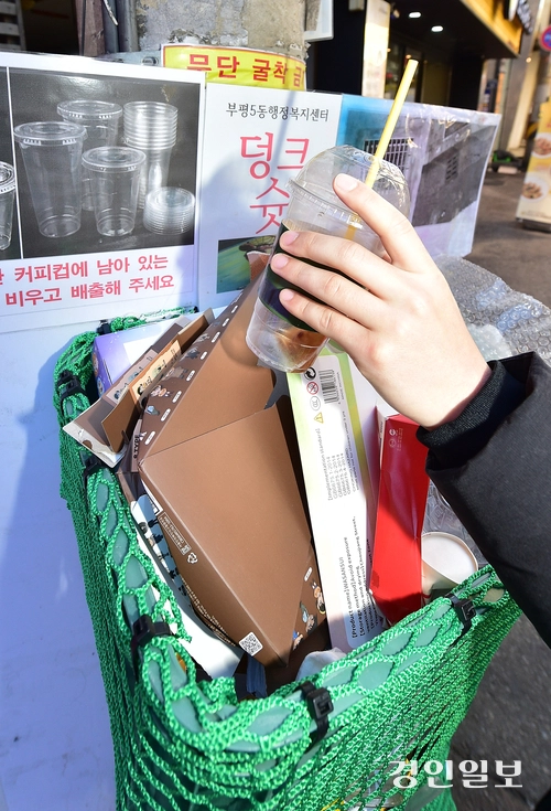 4일 오전 인천 부평문화의거리에 설치된 덩크슛 쓰레기통에 한 시민이 사용한 1회용컵을 버리고 있다. 2025.12.4 /조재현기자 jhc@kyeongin.com