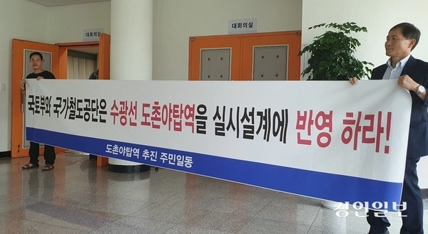 국가철도공단이 지난해 8월 개최한 ‘수서~광주 복선전철 환경영향평가서 설명회’에서 주민들이 도촌야탑역 신설을 요구하는 플래카드를 들고 있는 모습. /경인일보DB