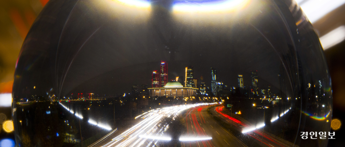 대한민국 전체를 흔들어 놓은 12·3 비상계엄 선포후 시민의 저항과 국회의 발 빠른 대응으로 6시간 만에 이뤄진 계엄 해제는 빛나는 K-민주주의의 저력을 보여준 순간이기도 하다. 계엄선포 1년을 3일 앞둔 30일 서울 여의도 국회의사당을 배경으로 놓여진 수정구슬에 국회 야경과 차량 궤적이 반영돼 일련의 위기 극복과정을 상징적으로 보여주고 있다. 2025.11.30 /조재현기자 jhc@kyeongin.com