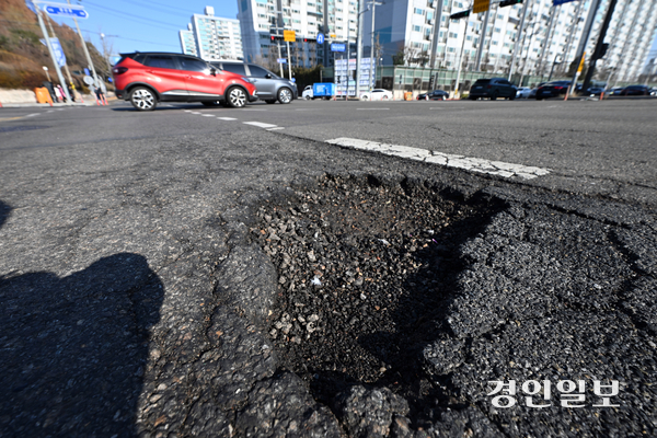 최근 잦은 눈·비가 내리면서 도로 곳곳에 포트홀이 생겨 운전자들의 안전을 위협하고 있다. 18일 오후 수원시내 한 도로가 파손돼 있다. 2025.12.18 /최은성기자 ces7198@kyeongin.com