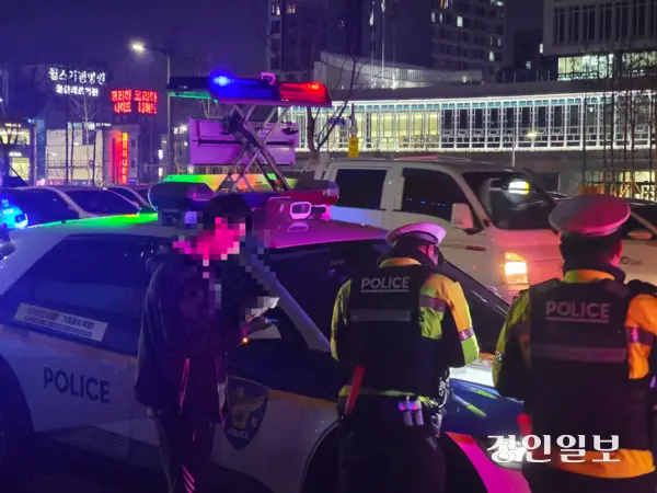 18일 저녁 경기남부경찰청이 수원시청역 인근 도로에서 음주단속을 진행하는 모습. 단속에 적발된 남성이 경찰에 조사를 받고 있다. 2025.12.18 /고건기자 gogosing@kyeongin.com