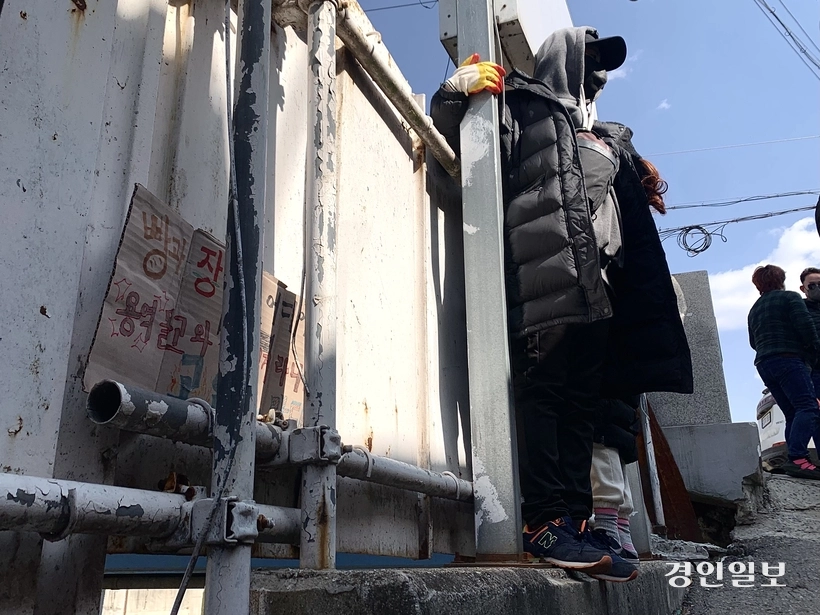 2024년 3월 8일 오후 1시40분께 파주시 용주골 성매매 집결지에서 이곳 종사 여성이 담벼락 위에 올라가 펜스 철거를 막으려 시위하고 있다. 2024.3.8 /유혜연기자 pi@kyeongin.com