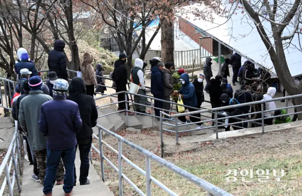 경기불황 속에 물가 상승 등으로 경기도 내 무료급식소들이 운영난을 겪고 있다. 12일 오전 수원시 팔달산 무료급식소 ‘사랑의 집’에서 노숙인 등 취약계층들이 도시락을 받고 있다. 2026.1.12 /임열수기자 pplys@kyeongin.com