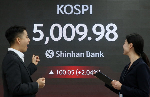 코스피가 장중 5,000을 넘어선 가운데 22일 서울 중구 신한은행 본점 로비에서 딜러들이 미소 짓고 있다. 2026.1.22 /신한투자증권 제공