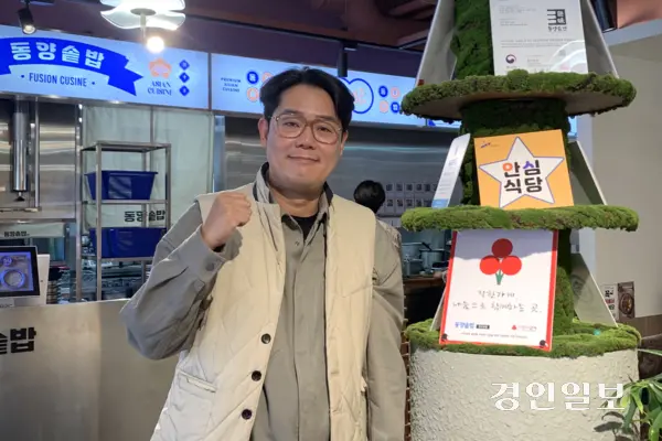 안산 중앙동 사랑의열매 착한가게 ‘동양솥밥’ 대표 이민규(46)씨가 매장 내 설치된 착한가게 인증 표식 앞에서 기념 촬영을 하고 있다. 해당 매장은 매달 일정 금액을 정기 기부하며 나눔에 참여하고 있다. 2026.1.28 /유혜연기자 pi@kyeongin.com