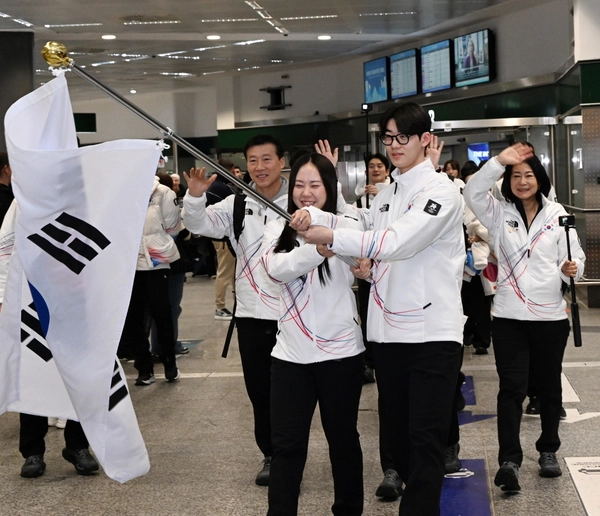 2026 밀라노·코르티나담페초 동계올림픽에 출전하는 대한민국 선수단의 스피드스케이팅 박지우와 쇼트트랙 이준서가 31일(한국시간) 이탈리아 밀라노 말펜사국제공항에서 태극기를 들고 입국장에 들어서고 있다. 2026.1.31 /연합뉴스